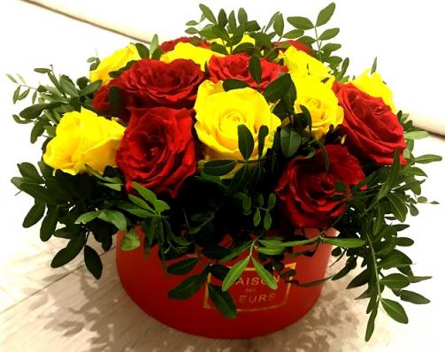 Красные и жёлтые розы в шляпной коробке